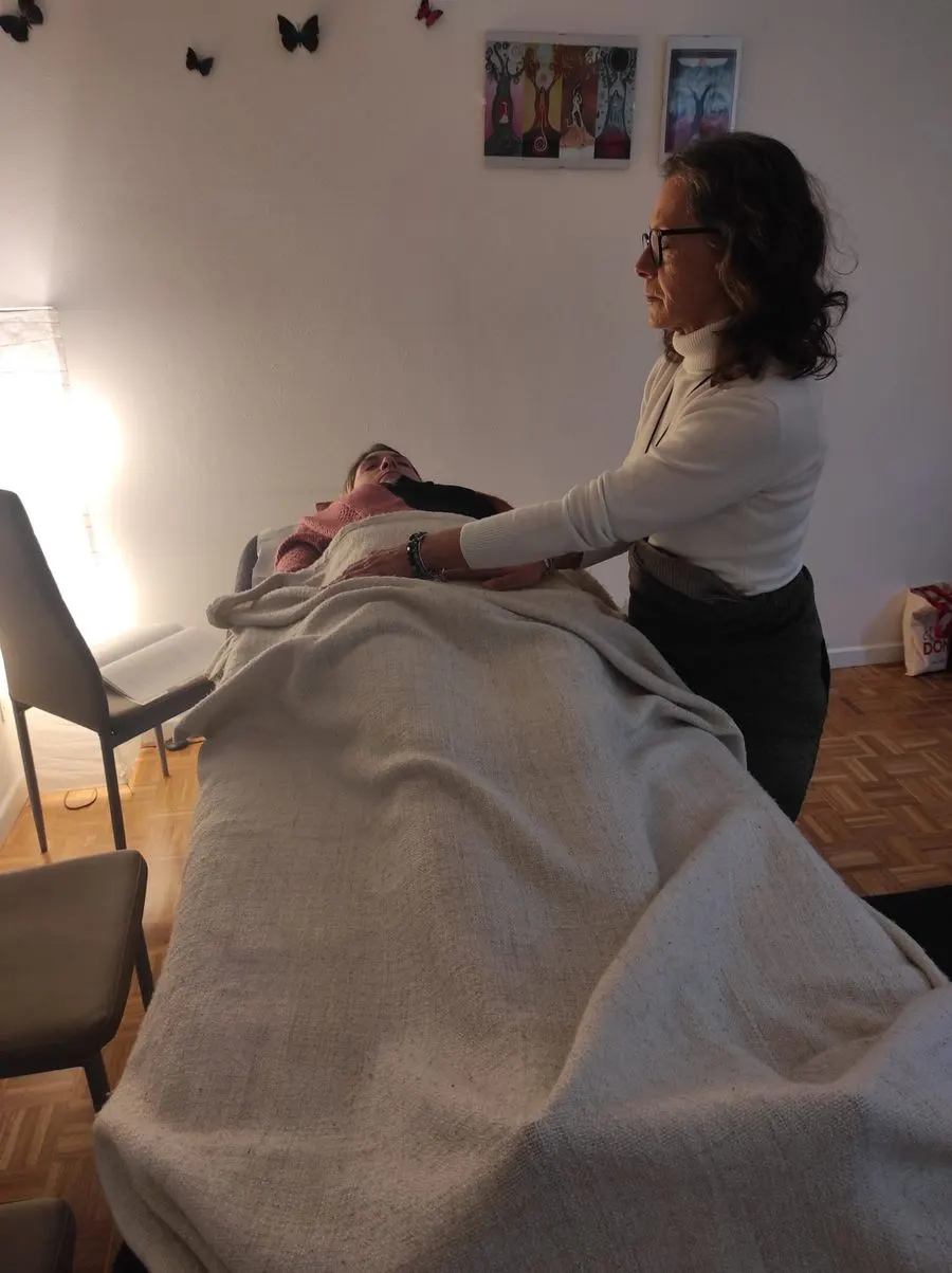 Un'allieva pratica Reiki con una compagna sul lettino